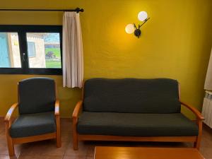 Serra de DaróCan Pujol - Turismo Rural的黄色墙壁的房间,两把椅子