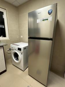 迪拜Palm Inn Hostel的厨房配有冰箱和洗衣机