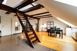 基尔Exklusive Apartments in Kieler City的阁楼设有木制楼梯和用餐室
