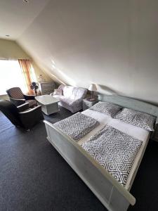 米兹多洛杰Willa Wicko - Międzyzdroje - apartamenty z aneksem - widok na Zalew Szczeciński的一间卧室配有一张大床、一张沙发和一张沙发。