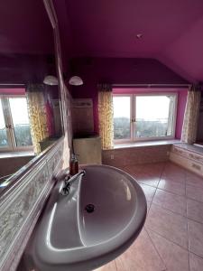 米兹多洛杰Willa Wicko - Międzyzdroje - apartamenty z aneksem - widok na Zalew Szczeciński的紫色客房内带大浴缸的浴室