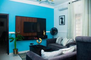Abeokuta3Tee Serviced Apartment Abeokuta的蓝色的客厅配有沙发和电视