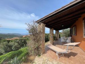 帕拉迪索海岸Villa Rocce Rosse的房屋内带桌子和长凳的庭院