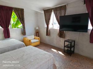 帕潘特拉德奧拉特Posada Familiar Papantla的酒店客房设有两张床和一台平面电视。