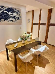 魏尔堡Wohnung in Weilburg am Schloss的一间带桌子和两把白色椅子的用餐室