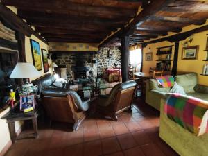 皮苏埃加河畔塞尔韦拉Casa Simón的客厅配有皮革家具和石墙