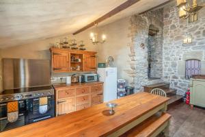 卡尔迪科特Medieval Manor的厨房配有木制橱柜和木桌。