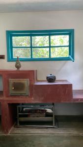 阿尤鲁奥卡Casa do Bosque的窗户在一间房间里,有红色长凳,上面有碗