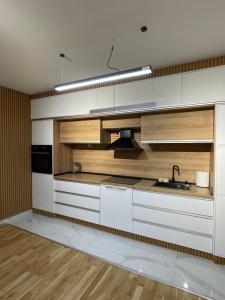 斯特鲁米察Diamond Apartment的厨房配有白色橱柜和水槽