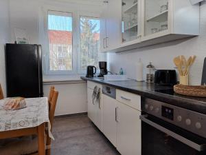 MuldensteinBurgK59, 3 BR, 6 Beds, TV, Kitchen and Bath的厨房配有白色橱柜、桌子和桌子。