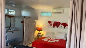 帕皮提DAMYR PLACE的一间卧室配有一张带红色毯子的床