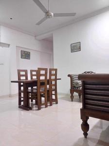 KelaniyaCamélia Résidence的客房设有椅子、桌子和吊扇。