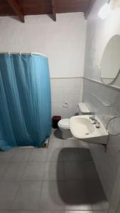 SaladilloA CAZON QUITADO的浴室配有水槽、卫生间和蓝色的浴帘