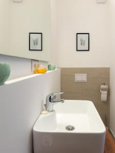 哥鲁拜克Golubina 3 - Soba sa Sopstvenim Kupatilom的浴室里的一个白色水槽,墙上有两张照片