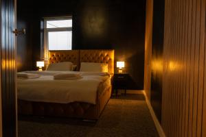 特伦特河畔斯托克The Orange County的一间卧室配有一张带两盏灯的床和一扇窗户。