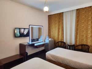 开罗赫利奥波利斯奥艾西斯酒店的酒店客房配有两张床和一张带镜子的书桌