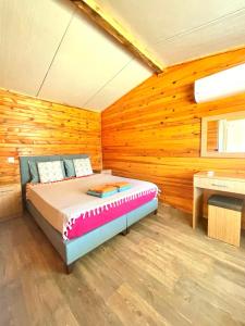 阿德拉桑Adrasan Yıldız Bungalow Tatil Köyü的卧室配有一张床铺,位于带木墙的房间内