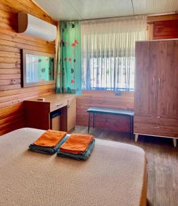 阿德拉桑Adrasan Yıldız Bungalow Tatil Köyü的一间卧室配有一张床,上面有两条毛巾