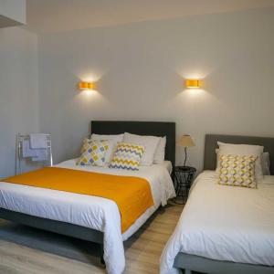 巴拉吕克莱班LE CENTRAL HOTEL BAR RESTAURANT的一间卧室配有两张床,墙上有两盏灯