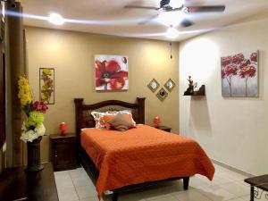 科潘玛雅遗址Habitación Doble Mayan Plaza的一间卧室配有一张带橙色毯子的床
