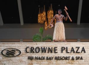 南迪Crowne Plaza Fiji Nadi Bay Resort & Spa, an IHG Hotel的站在标志上的人的雕像