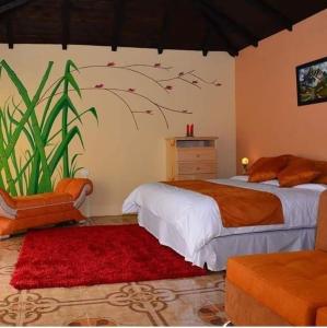 巴尼奥斯Orquideas Runtun的一间卧室配有一张床和红色地毯