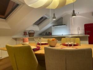 昂热Loft de 110m² dans le cœur historique d'Angers的一间带木桌和椅子的厨房以及一间用餐室