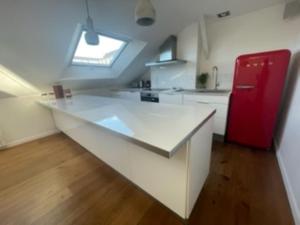 昂热Loft de 110m² dans le cœur historique d'Angers的一间白色的大厨房,配有红色冰箱