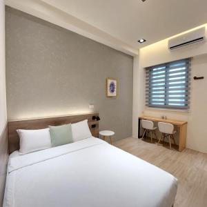 Hsing-wen森之羽民宿的卧室设有一张白色大床和一扇窗户。