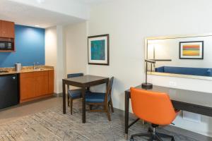 杰克逊维尔杰克逊维尔机场智选假日套房酒店的客房设有书桌和桌椅。