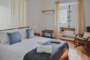 奥比多斯Casa de Campo da Quinta da Pegada的一间卧室配有一张大床和一把椅子