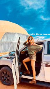 瓦迪拉姆Julia Rum Luxury Camp的坐在汽车敞开的门上的女人