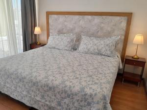 圣地亚哥Terraza Santa Lucia,Suites "Como en su Casa"的一间卧室配有一张带花卉床罩和两盏灯的床。