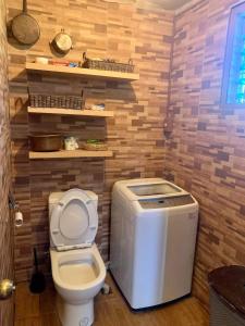 MalaybalayBliss Accommodation的木质墙壁的客房内设有带卫生间的浴室