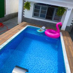 索莱马Recanto Caiçara的游泳池配有粉色天鹅和玩具