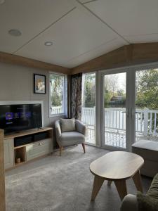 塔特舍尔Luxury Lakeside Lodge, Hot Tub & Private Fishing的客厅配有电视、沙发和桌子