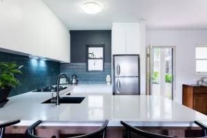 悉尼Balmain Designer 1 Bedroom Apartment with Parking的厨房配有水槽和冰箱