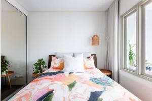 悉尼Balmain Designer 1 Bedroom Apartment with Parking的一间卧室配有一张带五颜六色棉被的床
