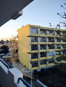 马斯帕洛马斯Epicentro Maspalomas的一座黄色的公寓楼正在建设中,设有脚手架