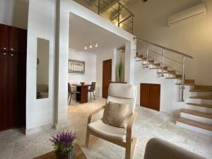 圣多明各The Sanctuary的客厅配有白色椅子和楼梯