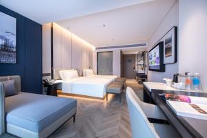广州广州番禺珠宝城亚朵酒店的酒店客房带一张床、一张桌子和椅子