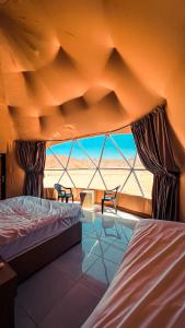 瓦迪拉姆Sama Wadi Rum的一间设有两张床的卧室,享有沙漠美景