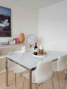 阿雷西费El Reducto Suite的餐桌、白色椅子和一瓶葡萄酒