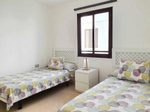 阿雷西费El Reducto Suite的一间卧室设有两张床和窗户。