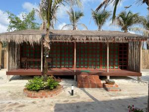 Phumĭ Srê ThmeiNov Koh Kong Resort的草屋顶和棕榈树小屋
