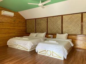 Phumĭ Srê ThmeiNov Koh Kong Resort的木墙客房的两张床