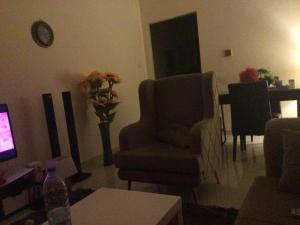 富查伊拉1 bedroom apartment的客厅配有椅子和桌子