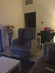 富查伊拉1 bedroom apartment的客厅配有蓝色椅子和桌子