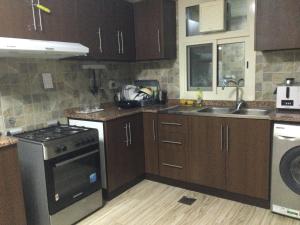 富查伊拉1 bedroom apartment的厨房配有木制橱柜和炉灶烤箱。