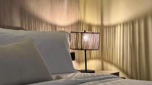 麦德林Sonata 44 Hotel Laureles的卧室配有白色的床和灯